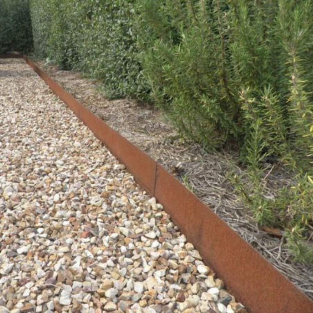 Corten steel edging holding gravel back from a planted border